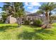 Home exterior view showcasing a screened pool area, mature landscaping, and well-maintained lawn at 1858 Mira Lago Cir, Ruskin, FL 33570