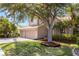 Exterior view showcasing mature landscaping, including a large shade tree and meticulously maintained lawn at 1858 Mira Lago Cir, Ruskin, FL 33570