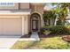 The front entrance features a decorative door, manicured landscaping, and a well-lit walkway at 1858 Mira Lago Cir, Ruskin, FL 33570
