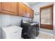 Well-equipped laundry room featuring a washer, dryer, sink, and upper cabinets for storage at 1858 Mira Lago Cir, Ruskin, FL 33570