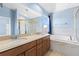 Bright bathroom with double vanity, soaking tub, and separate glass-enclosed shower at 1858 Mira Lago Cir, Ruskin, FL 33570