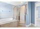 Luxurious bathroom showcasing a soaking tub, glass-enclosed shower, and neutral tile accents at 1858 Mira Lago Cir, Ruskin, FL 33570