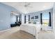 Inviting bedroom with blue walls, white bedding, and a comfortable seating area near the window at 1858 Mira Lago Cir, Ruskin, FL 33570