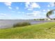 Lush green lawn meets the water's edge in this serene waterfront view, with calm waters extending to the horizon at 1858 Mira Lago Cir, Ruskin, FL 33570