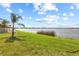 Picturesque view of the waterfront featuring a lush lawn gently sloping towards the tranquil water's edge at 1858 Mira Lago Cir, Ruskin, FL 33570