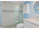 Modern bathroom featuring a walk-in shower, white vanity, and light blue walls at 18650 Gulf Blvd # 203, Indian Shores, FL 33785
