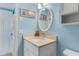 Bright bathroom with a modern vanity, framed mirror, and nautical artwork, complete with a stacked washer/dryer nearby at 18650 Gulf Blvd # 203, Indian Shores, FL 33785