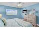 Comfortable bedroom with wood-look floors, a ceiling fan, and stylish coastal decor and furnishings at 18650 Gulf Blvd # 203, Indian Shores, FL 33785