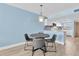 A dining area featuring blue walls with an adjacent kitchen and a dark wooden table at 18650 Gulf Blvd # 203, Indian Shores, FL 33785