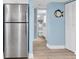 Hallway view with stainless steel refrigerator, bathroom, closet, and wood floors at 18650 Gulf Blvd # 203, Indian Shores, FL 33785