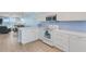 Bright, modern kitchen with white cabinets, granite countertops, and stainless steel appliances at 18650 Gulf Blvd # 203, Indian Shores, FL 33785