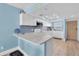 Bright kitchen featuring white cabinets, modern appliances, a breakfast bar, and blue accent tiles at 18650 Gulf Blvd # 203, Indian Shores, FL 33785