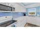 Updated kitchen featuring modern appliances, light wood flooring, and blue tiled backsplash at 18650 Gulf Blvd # 203, Indian Shores, FL 33785