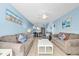 Open-concept living room with dining area featuring modern furnishings, beach-themed decor, and plenty of seating at 18650 Gulf Blvd # 203, Indian Shores, FL 33785