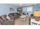 Cozy living room with blue walls, comfortable seating, and a sliding glass door to a balcony overlooking the beach at 18650 Gulf Blvd # 203, Indian Shores, FL 33785