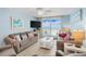 Inviting living room featuring ocean views from balcony access, comfortable sofas, and coastal decor at 18650 Gulf Blvd # 203, Indian Shores, FL 33785