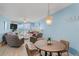 Cozy living room with comfortable seating, dining table, and sliding glass doors to balcony at 18650 Gulf Blvd # 203, Indian Shores, FL 33785