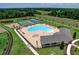 Aerial view of community pool, tennis court, basketball court, playground, and surrounding green space at 18657 Obregan Dr, Spring Hill, FL 34610
