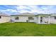 Manicured backyard featuring lush lawn, well-maintained home exterior, and covered patio at 18657 Obregan Dr, Spring Hill, FL 34610