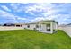 Well-maintained backyard with lush green grass, a covered patio, and white privacy fence at 18657 Obregan Dr, Spring Hill, FL 34610