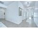 Long hallway featuring tile floors, white walls, decorative lighting and a decorative mirror at 18657 Obregan Dr, Spring Hill, FL 34610