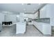 Modern kitchen with white cabinets, stainless steel appliances, a center island, and an adjacent dining area at 18657 Obregan Dr, Spring Hill, FL 34610