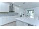 Modern kitchen features white cabinetry, stainless steel appliances, and an island with a sink at 18657 Obregan Dr, Spring Hill, FL 34610