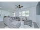 Bright living room boasts a ceiling fan, modern furniture, and large windows with white blinds at 18657 Obregan Dr, Spring Hill, FL 34610