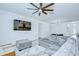 Comfortable living room with a large sectional sofa, decorative rug, ceiling fan, and mounted TV for relaxation at 18657 Obregan Dr, Spring Hill, FL 34610