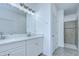 Bathroom with double sinks, quartz countertops, large mirror and walk-in shower at 18657 Obregan Dr, Spring Hill, FL 34610