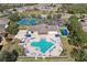 Aerial view showcasing the community pool, clubhouse, tennis courts, and sand volleyball court at 1919 Oswego Dr, Holiday, FL 34691