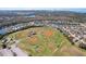 Aerial shot of baseball park surrounded by trees and neighborhood with water views in the distance at 1919 Oswego Dr, Holiday, FL 34691