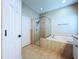 Bright bathroom featuring a tiled shower, soaking tub, and neutral-toned tile flooring at 1919 Oswego Dr, Holiday, FL 34691