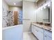 Bathroom showcasing granite countertop, white cabinets, and a beautifully tiled shower at 1919 Oswego Dr, Holiday, FL 34691