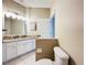 Well-lit bathroom featuring a granite countertop, white cabinets, and a toilet with a door for privacy at 1919 Oswego Dr, Holiday, FL 34691