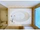 Overhead shot of a large bathtub and shower featuring tile surround, and a window for natural light at 1919 Oswego Dr, Holiday, FL 34691