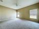 Bedroom with neutral carpet, ceiling fan, and two large windows at 1919 Oswego Dr, Holiday, FL 34691