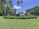 Community sign for Key Vista on a sunny day surrounded by green grass, shrubbery, and trees at 1919 Oswego Dr, Holiday, FL 34691
