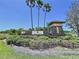 Key Vista entrance sign with palm trees, lush landscaping and stone pillars at 1919 Oswego Dr, Holiday, FL 34691