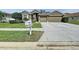 Frontal view of home including the front lawn, flower beds, and driveway at 1919 Oswego Dr, Holiday, FL 34691