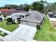 Single-story home with a well-kept lawn and a three-car garage at 1919 Oswego Dr, Holiday, FL 34691