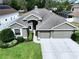 Inviting single-story home featuring manicured landscaping and a spacious three-car garage at 1919 Oswego Dr, Holiday, FL 34691