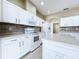 Beautiful white kitchen featuring updated appliances, white cabinets, and stone backsplash at 1919 Oswego Dr, Holiday, FL 34691