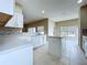 Bright kitchen featuring white cabinets, stone backsplash, tiled floors, and a center island at 1919 Oswego Dr, Holiday, FL 34691