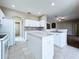 Bright kitchen featuring white cabinets, stone backsplash, tiled floors, and a center island at 1919 Oswego Dr, Holiday, FL 34691