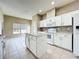 Kitchen with white cabinets, kitchen island, tiled floors, and stainless steel appliances at 1919 Oswego Dr, Holiday, FL 34691