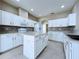 Well-lit kitchen boasts white cabinets, island, and a stone backsplash at 1919 Oswego Dr, Holiday, FL 34691