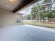 Screened-in lanai providing a relaxing view of trees, fence, and green yard at 1919 Oswego Dr, Holiday, FL 34691