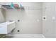 Laundry room with utility sink, wire shelving, and neutral paint for practical use at 1919 Oswego Dr, Holiday, FL 34691