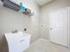 Utility laundry room with utility sink, wire shelving, and tile floor for practical use at 1919 Oswego Dr, Holiday, FL 34691